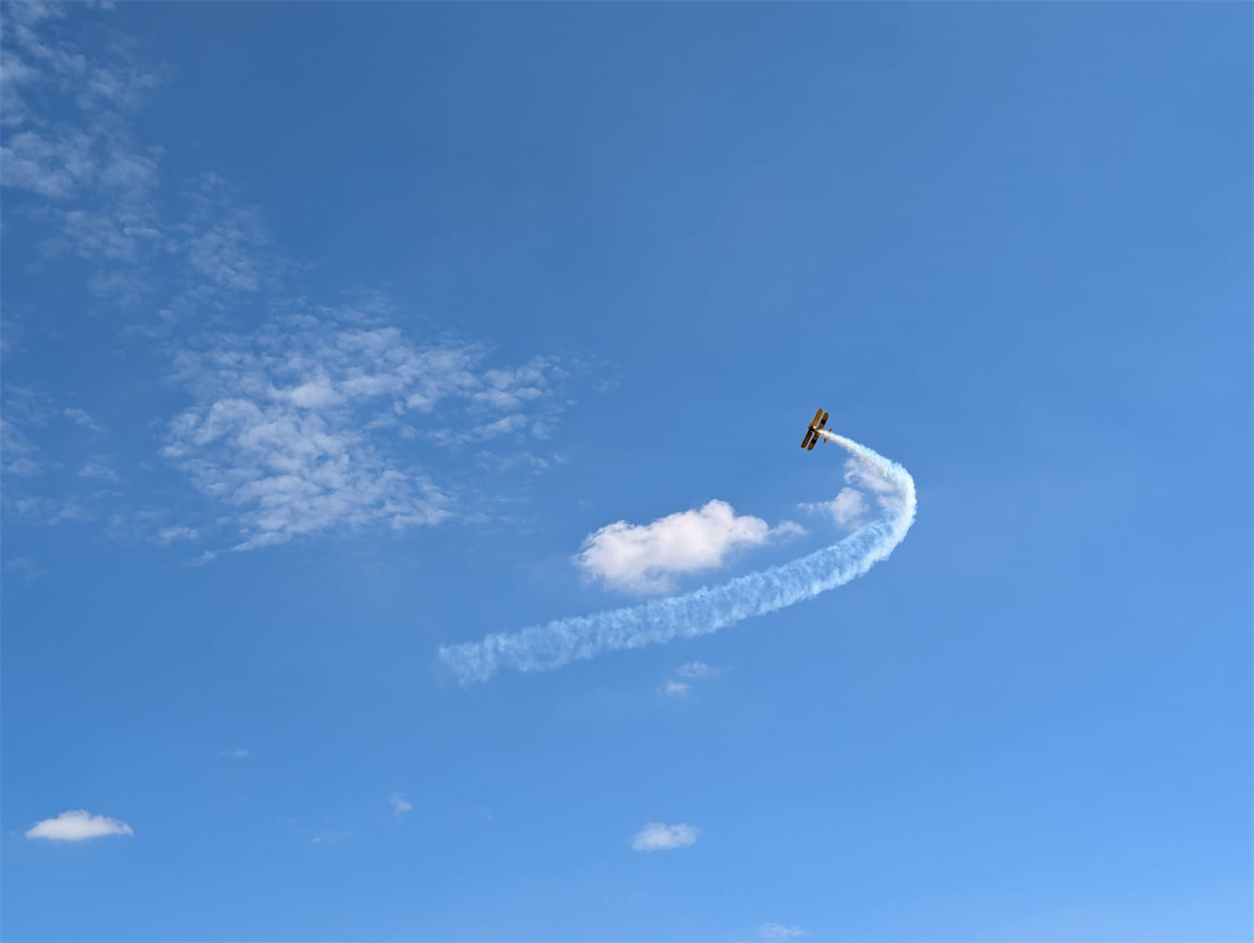 A photo of the aircraft, soaring through a vibrant blue sky.