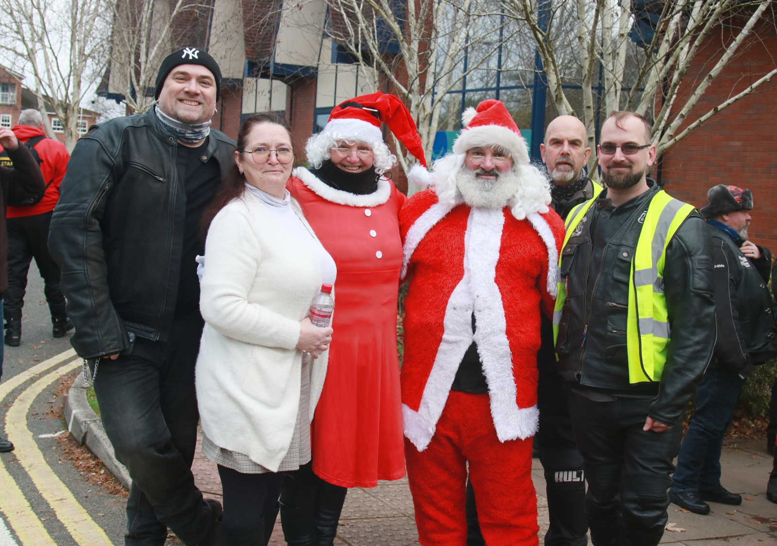 A cheerful photo featuring some guests and Santa Claus, all smiling together at the event.