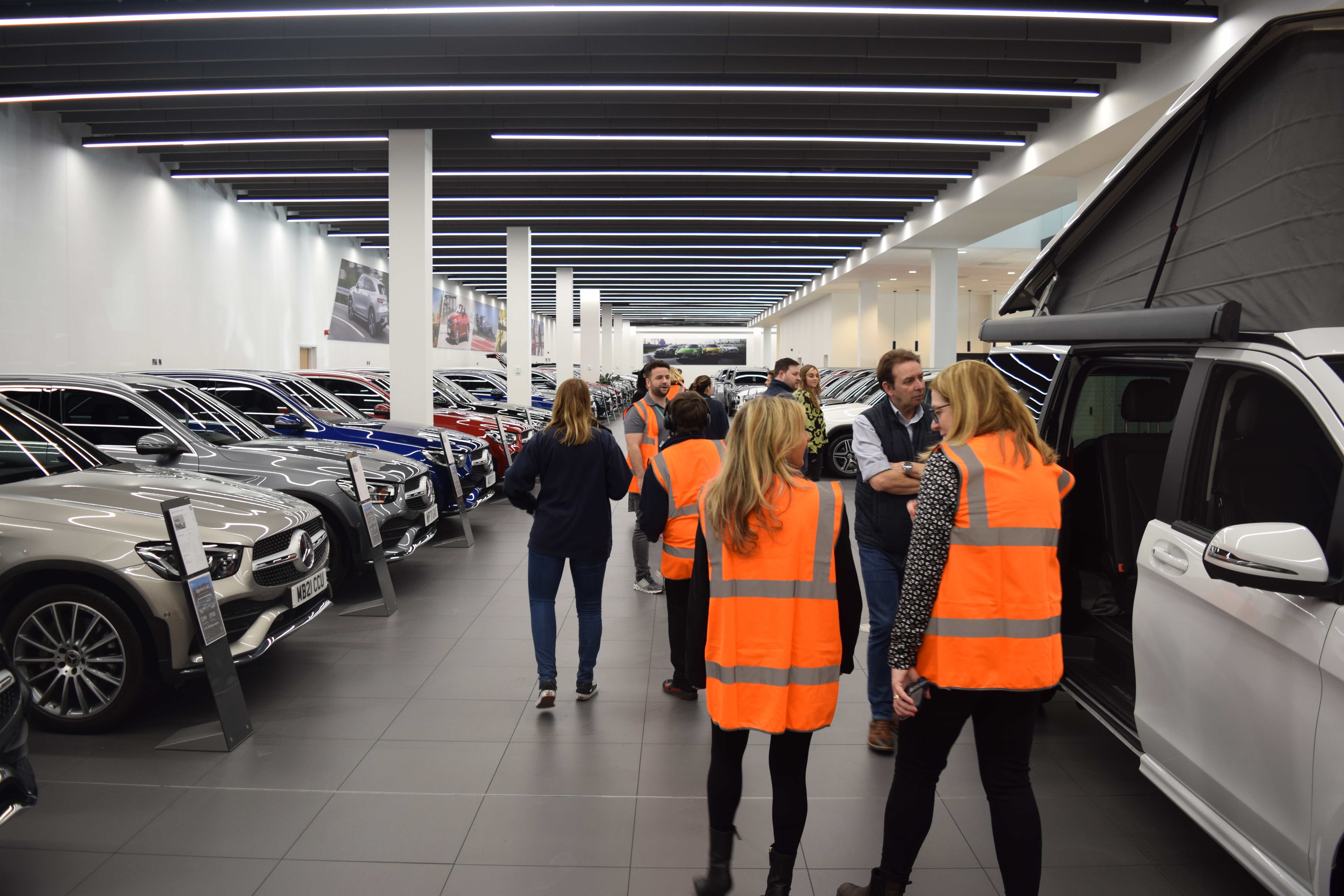 a group of students walking around the showroom
