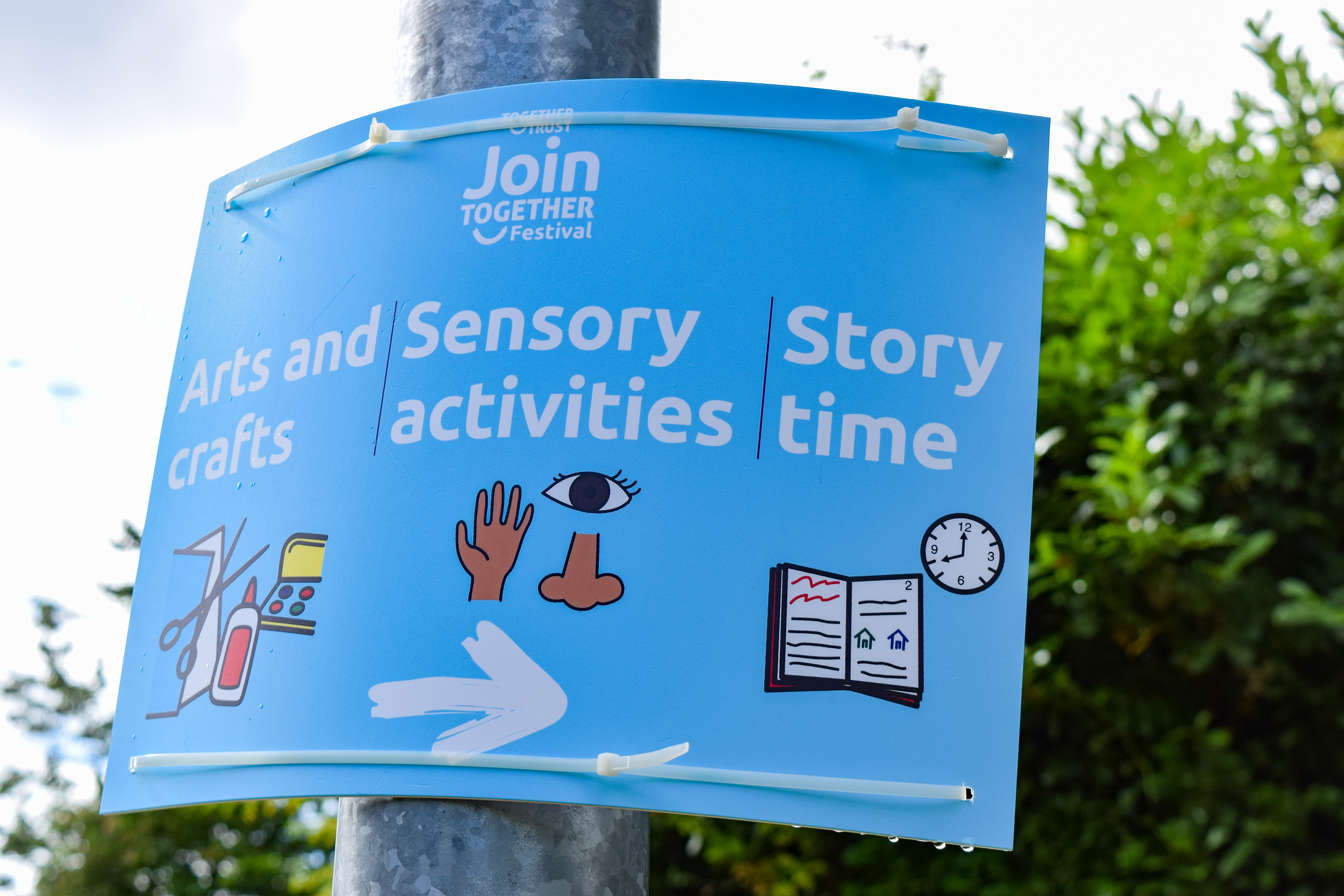A sign with light blue background and graphic illustrations that read: “Arts and crafts”, “Sensory activities” and “Story time”.