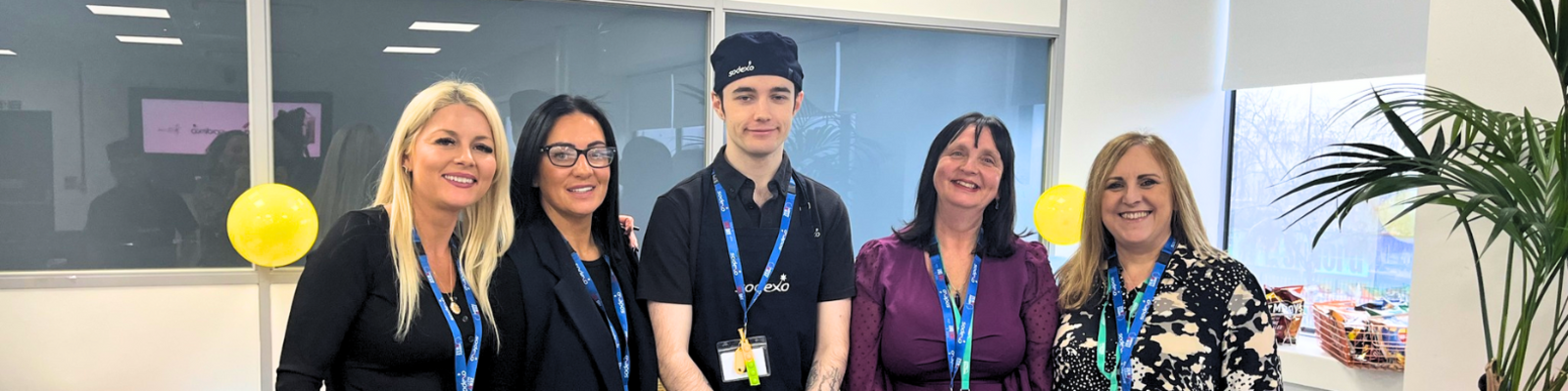 A student standing next to 4 proud staff members at his supported internship placement. 