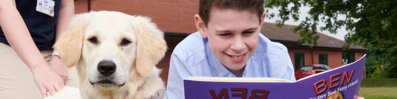 a student and a dog reading a book together