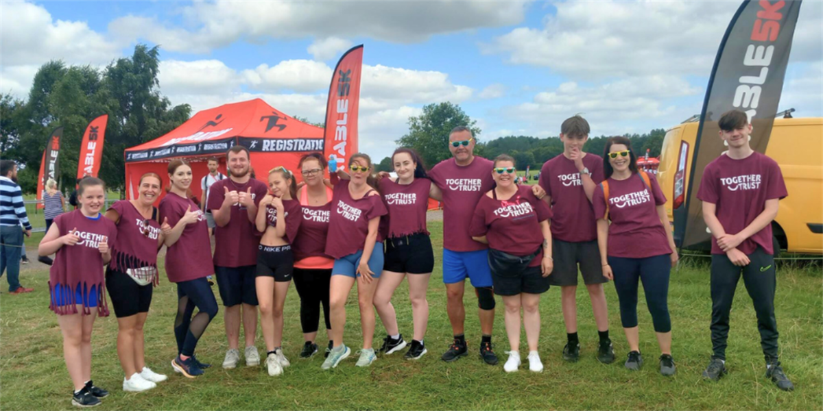 A snapshot of all 13 members of the Together Trust who participated in the inflatable 5k obstacle challenge. 