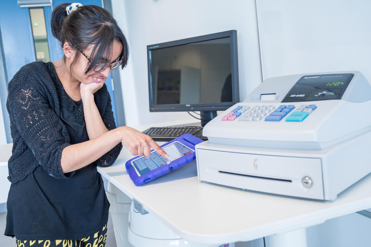 a bridge student using an iPad next to a till