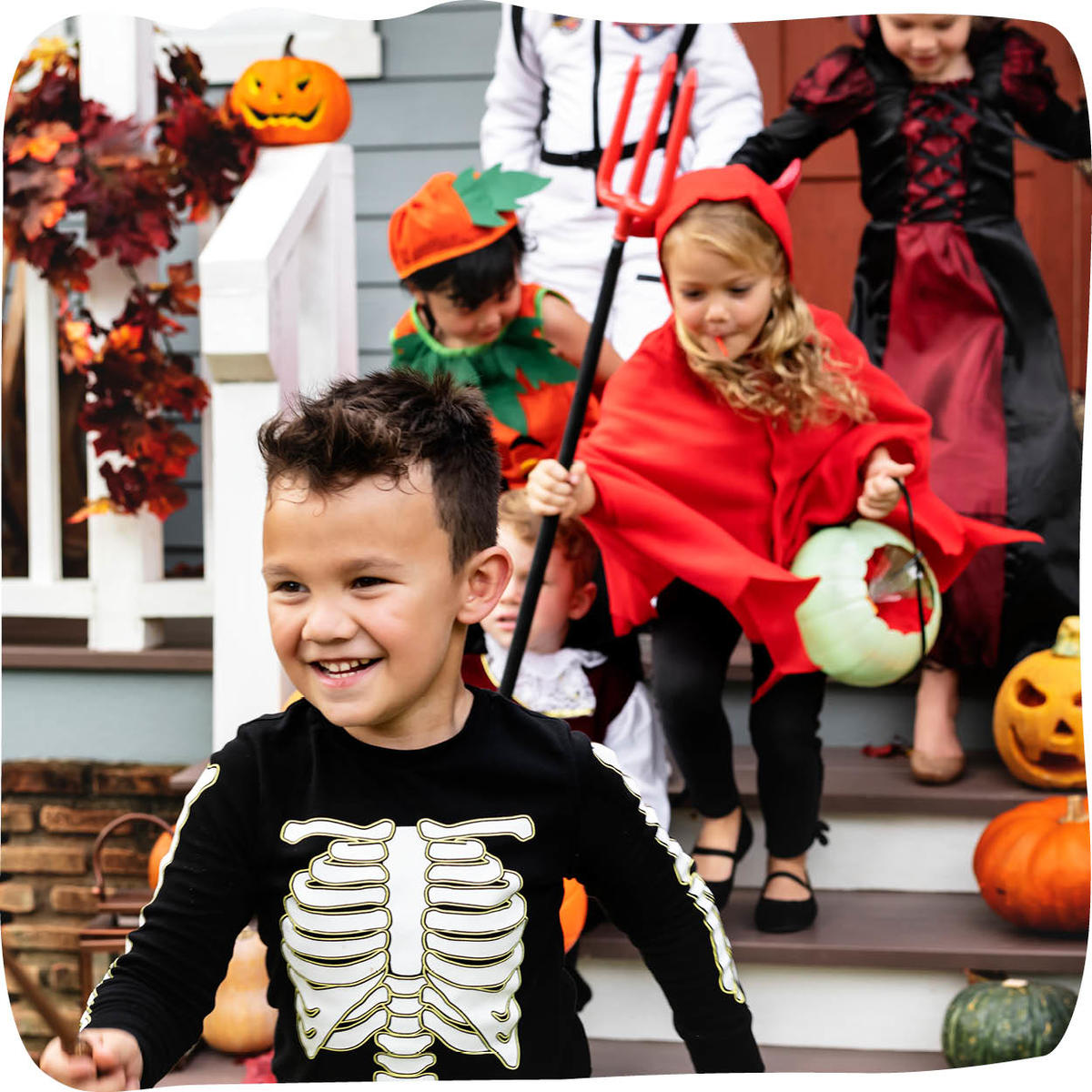 a group of children smiling as they trick or treat in halloween costumes