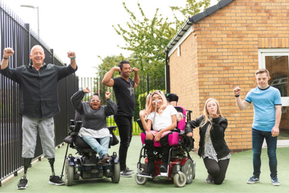 A group of people smiling at the camera and holding their arms in the air