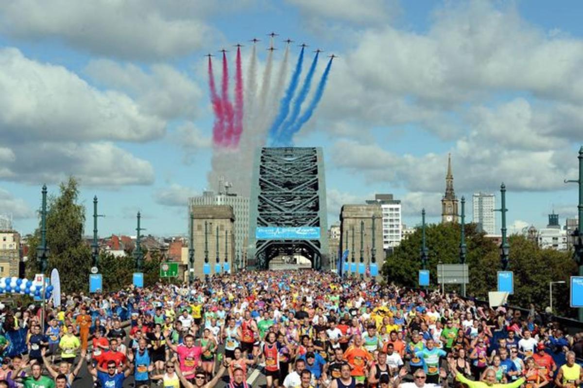 Hundreds of people running in the great north run with the red arrows flying above them