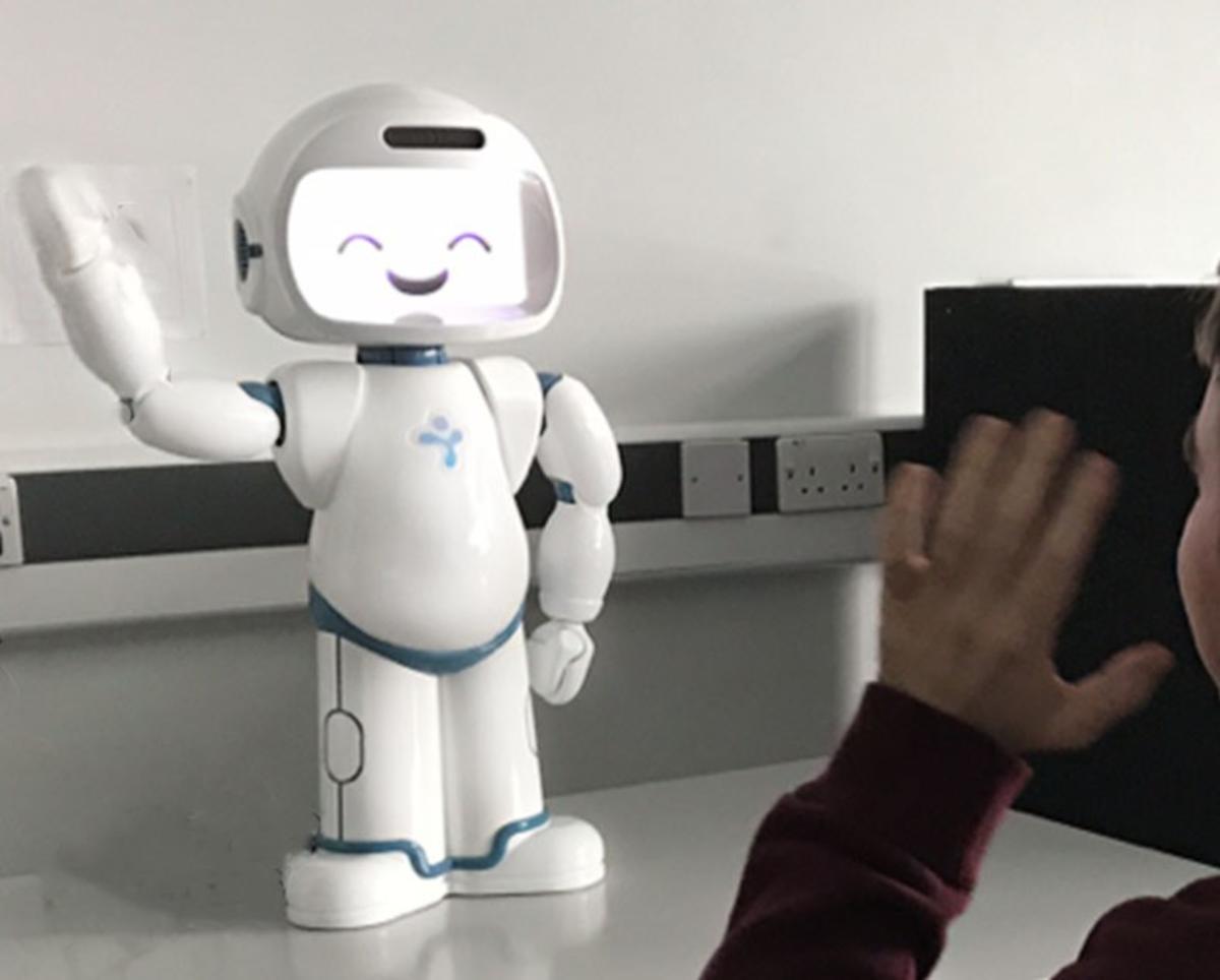 A robot waving with a person waving back at it