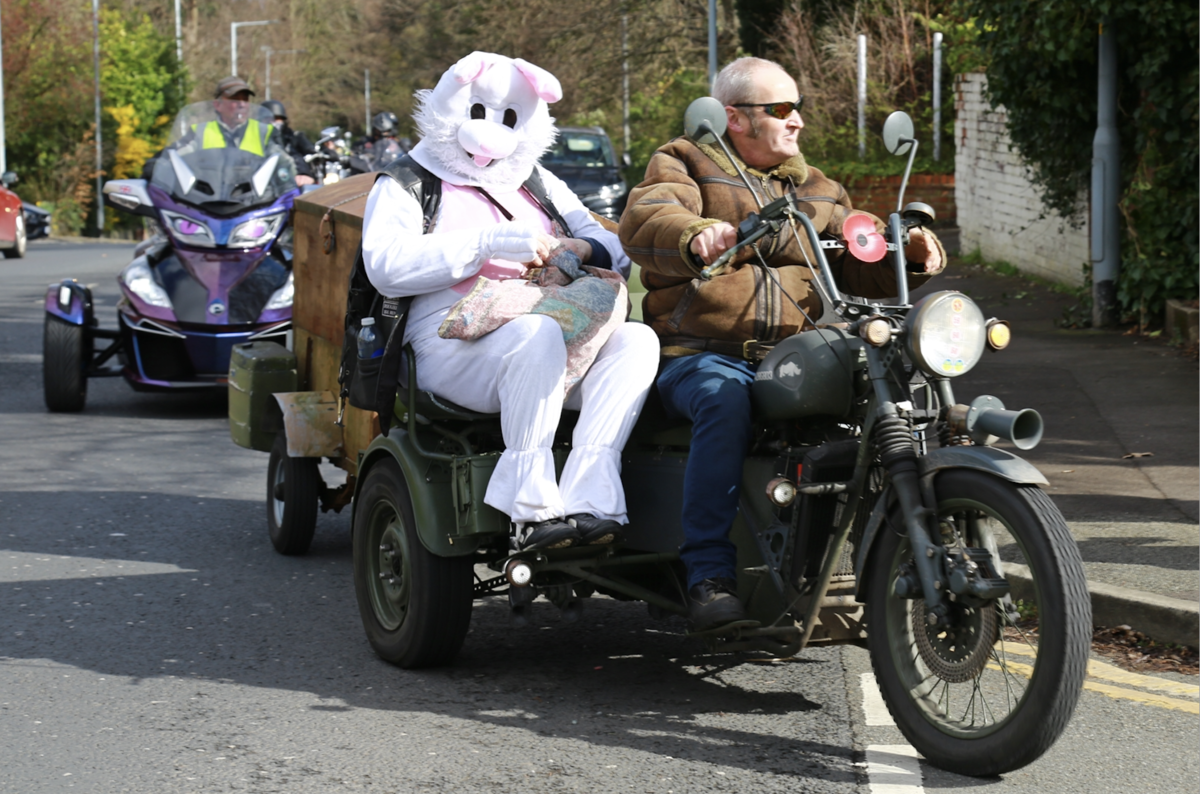 a Roughley's biker with a large white rabbit sat in a sidecar