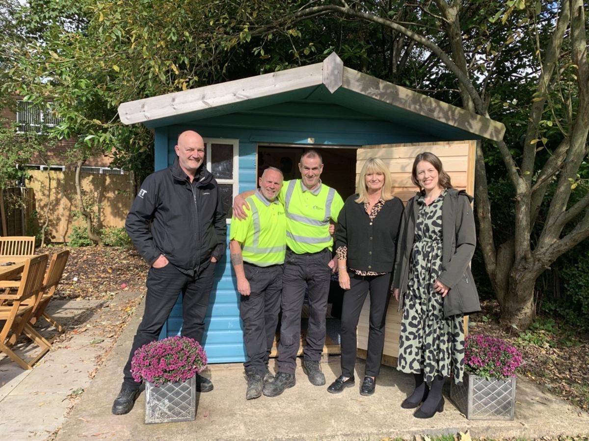 Captured in this image is the dedicated team from Manchester Airport along with staff from the Together Trust, standing proudly in front of the summerhouse.