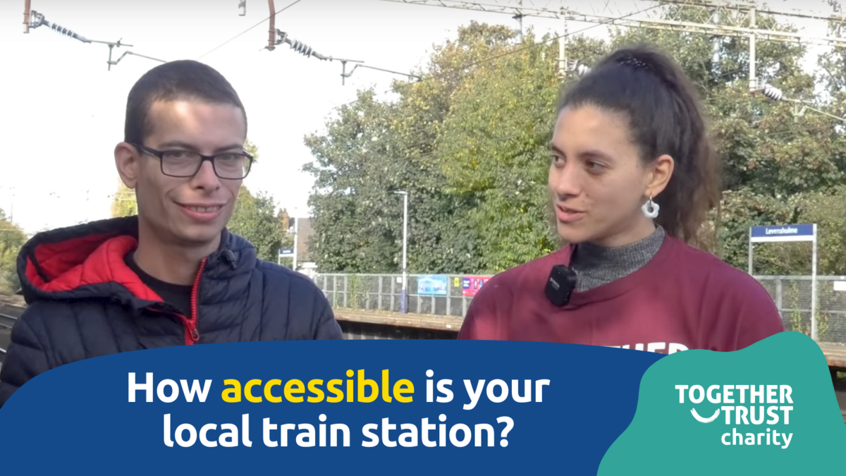 Nathaniel and Styliana talking on the platform of Levenshulme station.