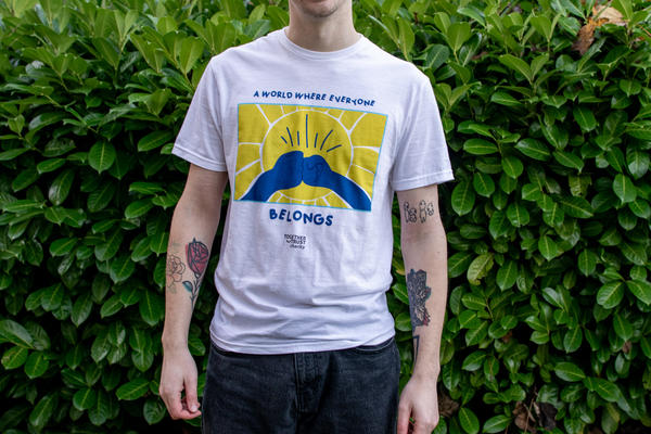 a man wearing a white t shirt with a yellow background in the middle and two fists touching 