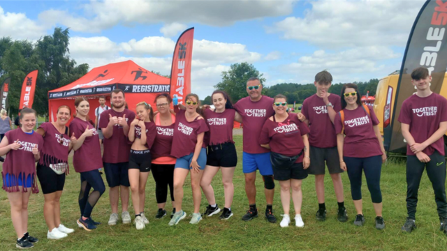 A snapshot of all 13 members of the Together Trust who participated in the inflatable 5k obstacle challenge. 