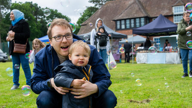 a man and a young boy smiling at bubbles in the air