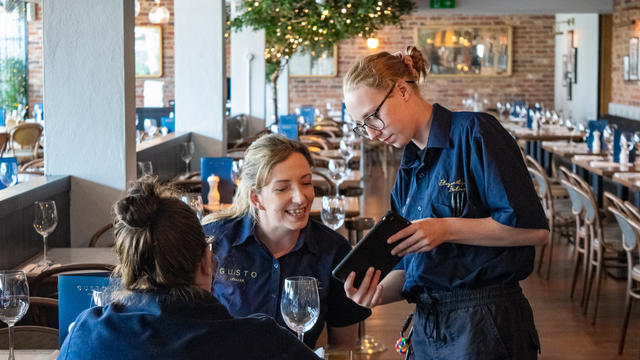 Student practicing customer service skills at Gusto restaurant.