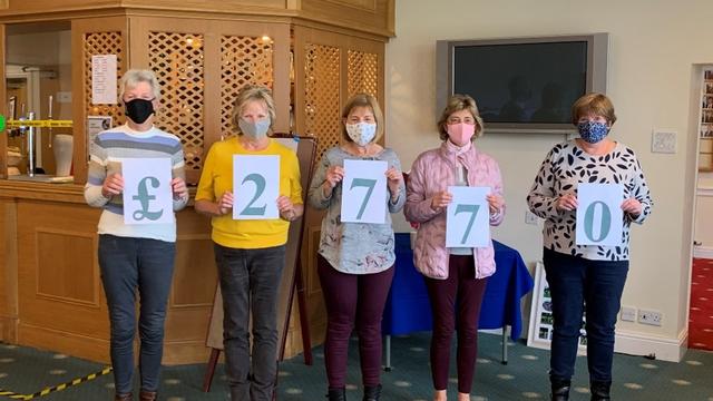 Members of Marple Golf club holding up the total that they raised in numbers