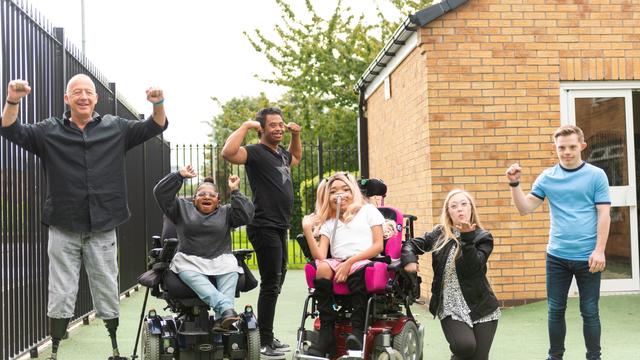 A snapshot which captures the genuine happiness of six individuals, each living with a unique disability. Their radiant smiles and confident poses are beautifully framed by the camera lens, presenting an image of resilience and joy.