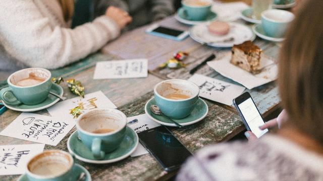 people chatting around empty coffee cups on a table