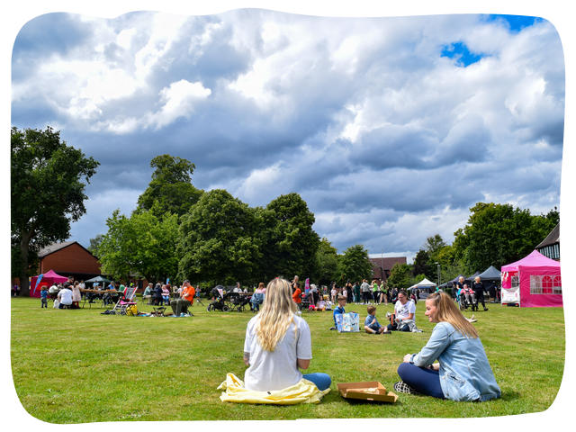 a group of people sat on grass at join together festival