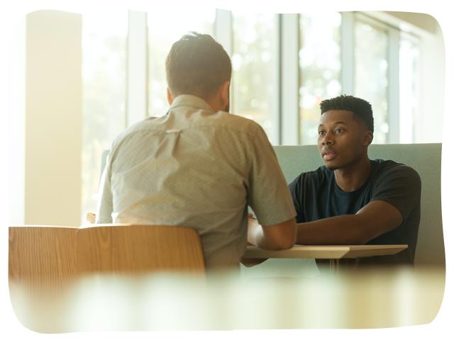 two people talking across a table