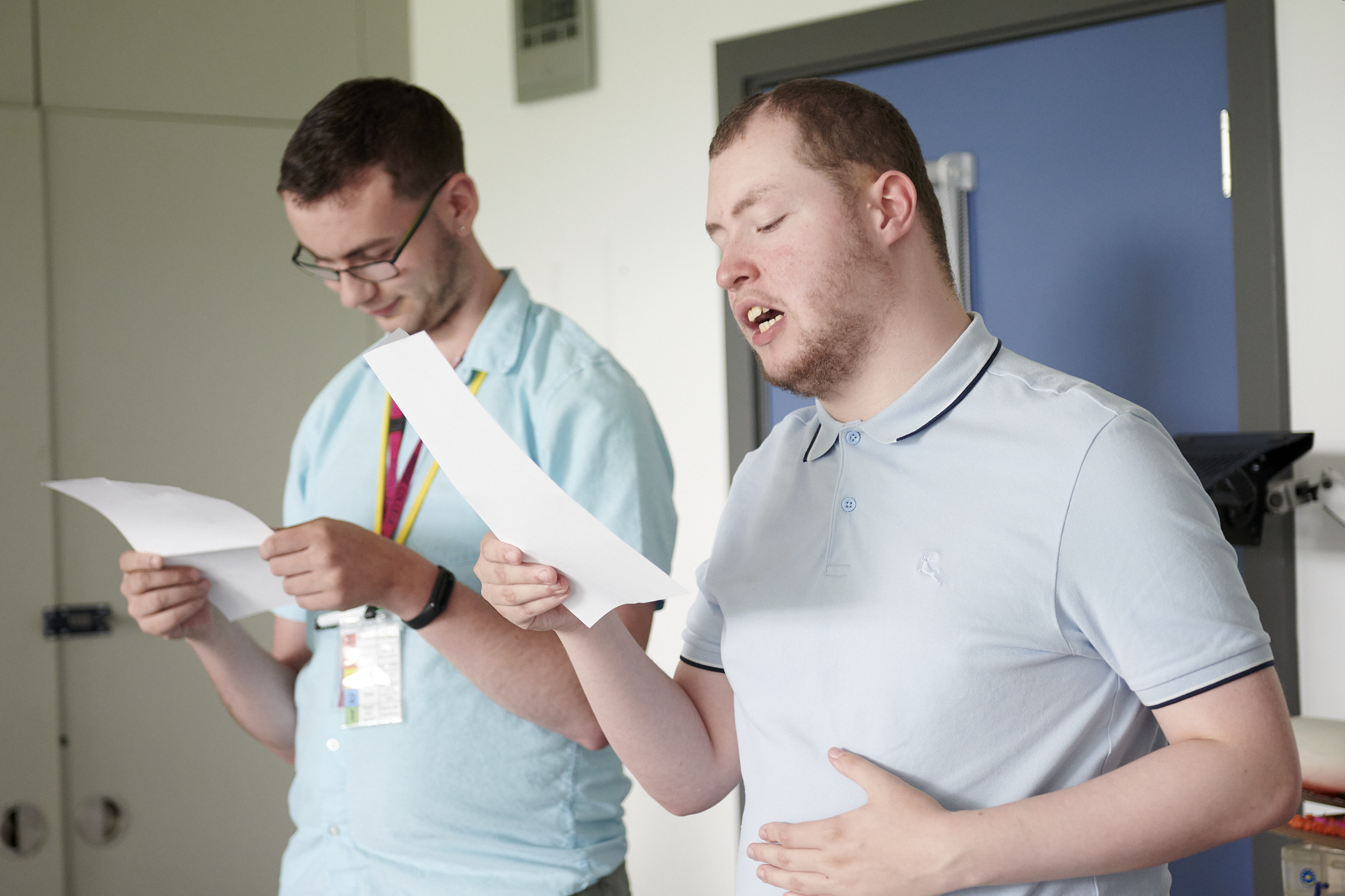 two young men, the same 2 actors as in the previous images, rehearsing in college. 